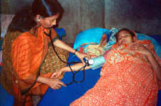 Copyright © 2002 Jean Sack/ICDDRB, Courtesy of Photoshare. Physician (L) at Matlab Hospital, Bangladesh, consulting a mother whose daughter is sick with diarrhea. The mother is feeding her daughter a rice-based Oral Rehydration Solution (ORS)